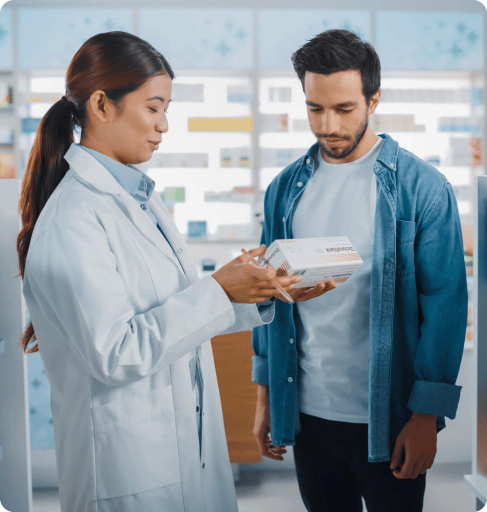 A pharmacist discussing a box of medication with a man